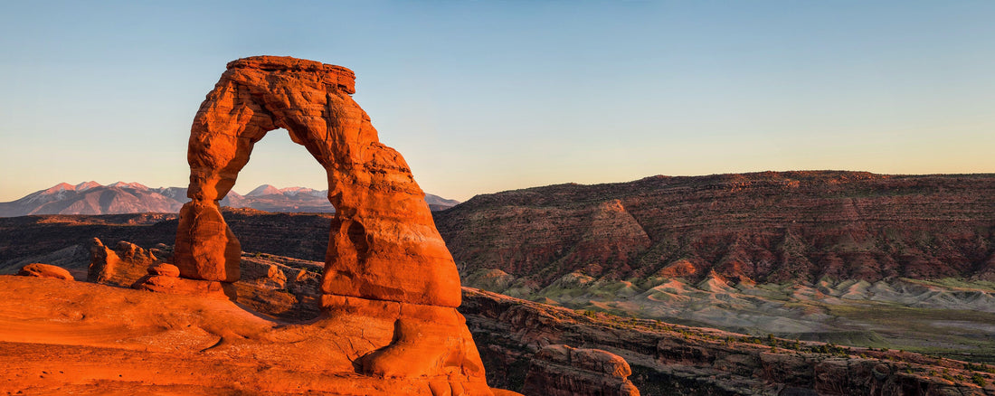 Delicate Arch glowing at sunset with the La Sal Mountains behind, Arches National Park